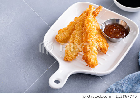 Cooked tempura shrimp on a plate with dipping sauce 113867779