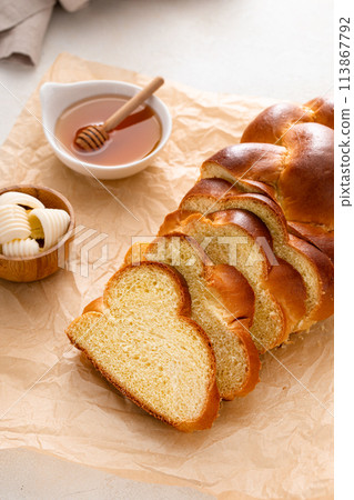 Homemade challah with honey sliced on the table 113867792