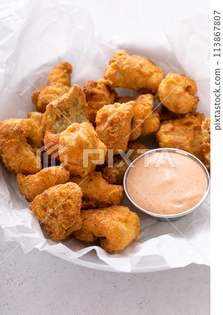 Catfish nuggets in a bowl with dipping sauce 113867807