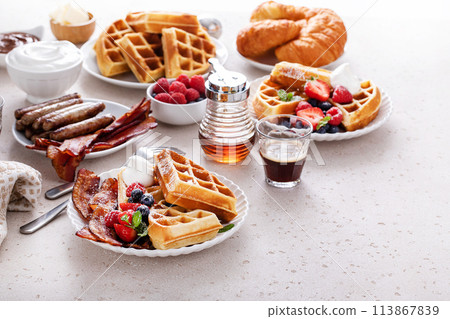 Waffles for breakfast with bacon and berries, breakfast table with variety of food Waffles for breakfast with bacon and berries, breakfast table with variety of food 113867839
