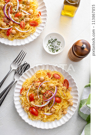 Spaghetti squash with chickpeas and tomatoes topped with red onion, low carb vegan recipe idea 113867855