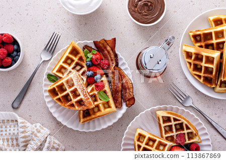 Waffles for breakfast with bacon and berries, breakfast table with variety of food Waffles for breakfast with bacon and berries, breakfast table with variety of food 113867869