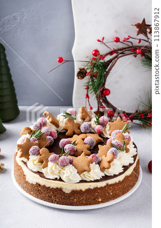 Christmas cake decorated with gingerbread cookies and sugared cranberries, holiday cheesecake idea 113867912