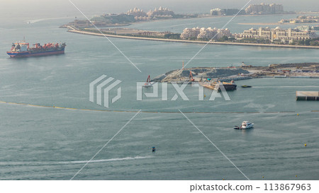 Aerial view of Palm Jumeirah man made island from JBR district before sunset timelapse. Dubai, UAE. Aerial view of Palm Jumeirah man made island from JBR district before sunset timelapse. Dubai, UAE. 113867963