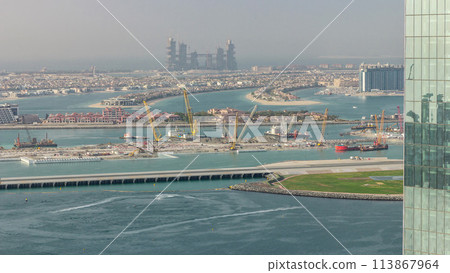 Aerial view of Palm Jumeirah man made island from JBR district before sunset timelapse. Dubai, UAE. Aerial view of Palm Jumeirah man made island from JBR district before sunset timelapse. Dubai, UAE. 113867964