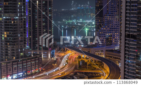 Aerial view to Dubai marina skyscrapers with construction site and Palm Jumeirah Island on background night timelapse. 113868049