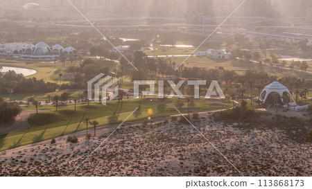 Golf course and Dubai Marina skyscrapers during sunset timelapse, Dubai, United Arab Emirates 113868173