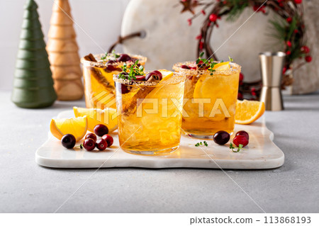 Christmas orange and cranberry margarita cocktail garnished with fresh cranberries and cinnamon 113868193