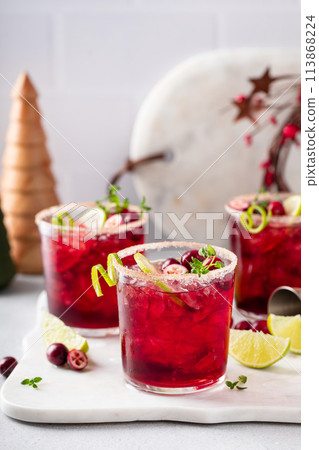 Christmas cranberry and lime margarita cocktail garnished with lime zest 113868224