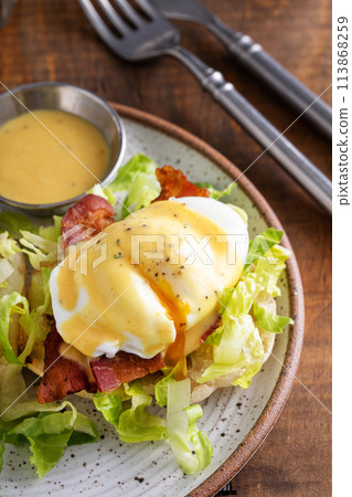 Egg benedict sandwich on english muffin with lettuce and bacon Egg benedict sandwich on english muffin with lettuce and bacon 113868259
