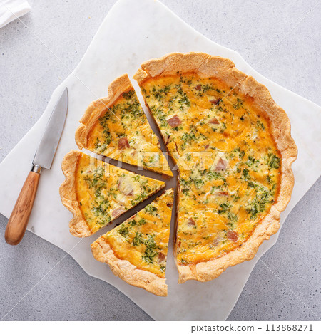 Homemade quiche with ham and cheese cut on the table 113868271