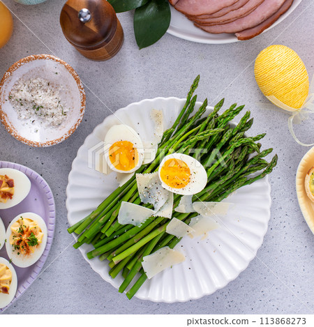 Asparagus cooked on a plate topped with parmesan 113868273