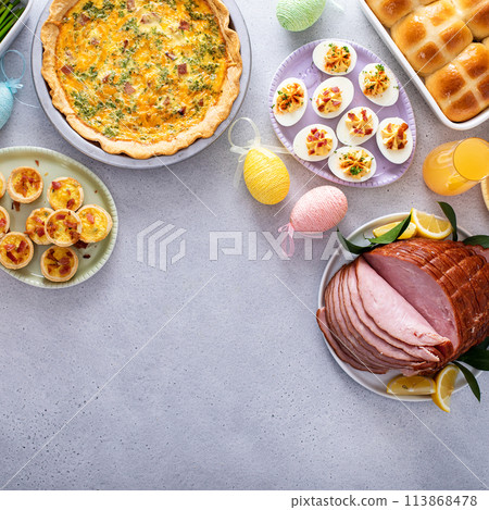 Easter brunch table with ham, quiche, hot cross buns 113868478