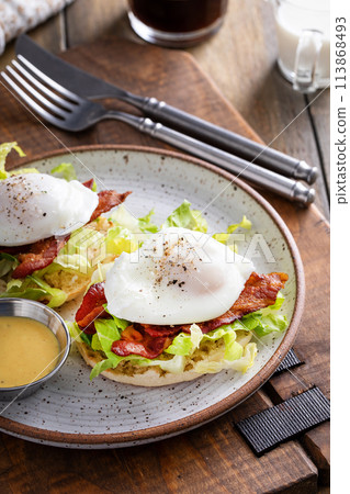 Eggs Benedict with bacon and lettuce on english muffins Eggs Benedict with bacon and lettuce on english muffins 113868493