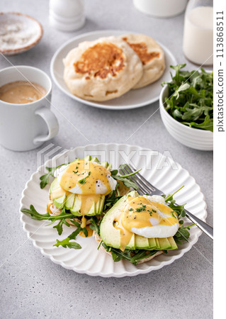 Healthy egg benedict with avocado and arugula 113868511