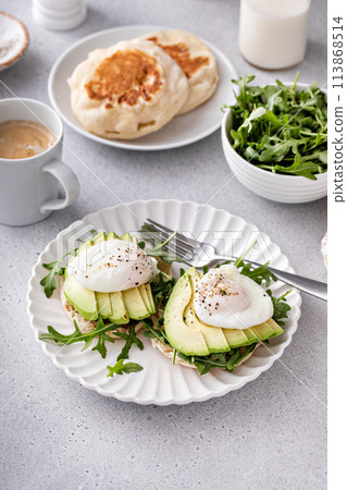 Healthy egg benedict with avocado and arugula 113868514