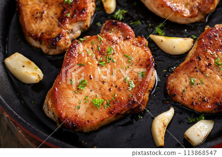 Pork chops cooked in a cast iron pan 113868547
