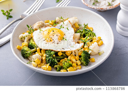 Healthy breakfast bowl with cooked vegetables and fried egg 113868786