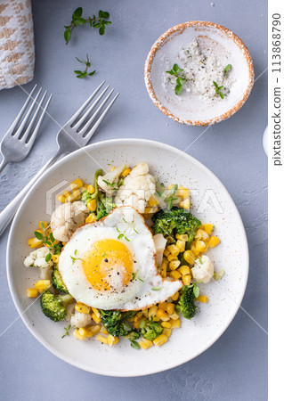 Healthy breakfast bowl with cooked vegetables and fried egg Healthy breakfast bowl with cooked vegetables and fried egg 113868790