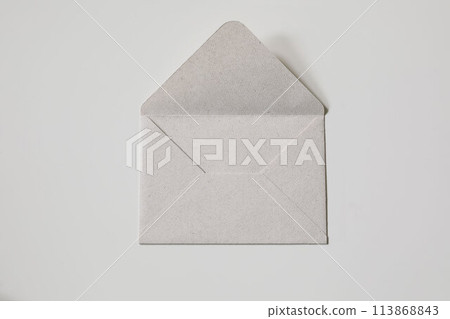 Close-up neutral textured paper envelope on beige background. Flat lay with copy space, top view. Mailing concept. Craft blank mockup for lettering, greeting card, postcard, invitation. No people. Close-up neutral textured paper envelope on beige background. Flat lay with copy space, top view. Mailing concept. Craft blank mockup for lettering, greeting card, postcard, invitation. No people. 113868843