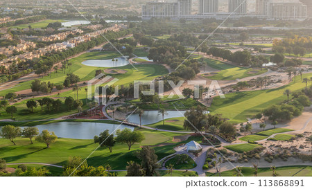 Aerial view to villas and houses with Golf course with green lawn and lakes timelapse Aerial view to villas and houses with Golf course with green lawn and lakes timelapse 113868891