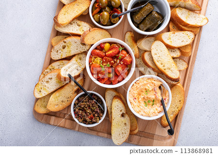 Snack board with toasted baguette and variety of dips Snack board with toasted baguette and variety of dips 113868981