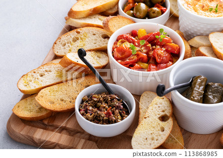 Snack board with toasted baguette and variety of dips Snack board with toasted baguette and variety of dips 113868985