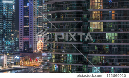 Aerial view of Dubai Marina residential and office skyscrapers with waterfront night timelapse 113869010