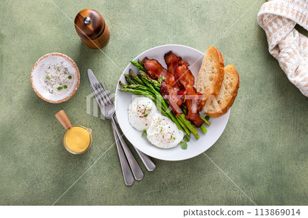 Healthy breakfast with poached eggs, bacon and asparagus 113869014