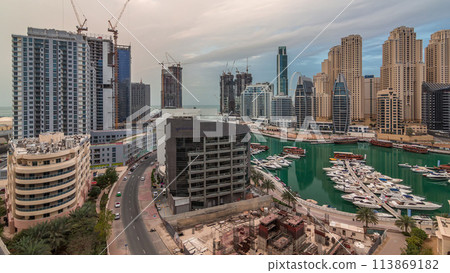 Luxury yachts parked on the pier in Dubai Marina bay with city aerial view timelapse 113869182