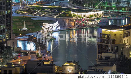 Top close up view of the bridge over man-made lake and some people walking in park 113869341