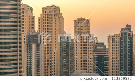 Dubai marina and JBR towers panorama day to night timelapse lights turn on. Dubai marina and JBR towers panorama day to night timelapse lights turn on. 113869583
