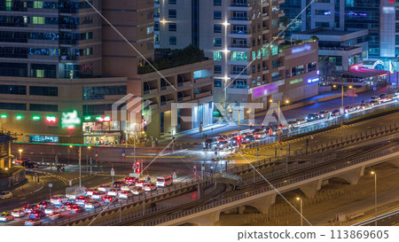 Aerial view of a road intersection in a big city night timelapse. Aerial view of a road intersection in a big city night timelapse. 113869605