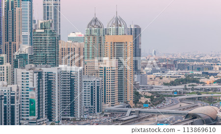 Dubai marina with traffic on sheikh zayed road panorama day to night timelapse lights turn on. 113869610