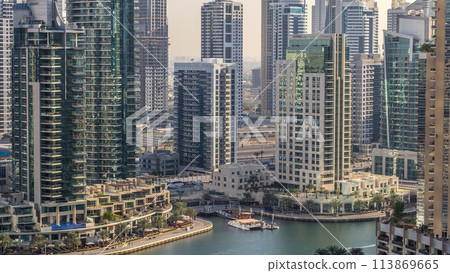 Beautiful aerial view of Dubai Marina promenade and canal with floating yachts and boats before sunset in Dubai, UAE. Beautiful aerial view of Dubai Marina promenade and canal with floating yachts and boats before sunset in Dubai, UAE. 113869665
