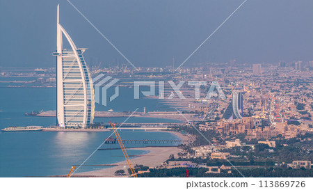 Aerial View of Jumeirah Beach and Dubai skyline with Burj Al Arab day to night timelapse, UAE Aerial View of Jumeirah Beach and Dubai skyline with Burj Al Arab day to night timelapse, UAE 113869726
