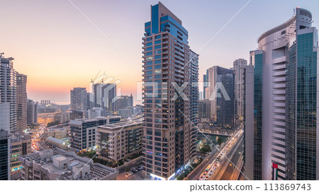 Aerial view of Dubai Marina after sunset from a vantage point day to night timelapse. 113869743