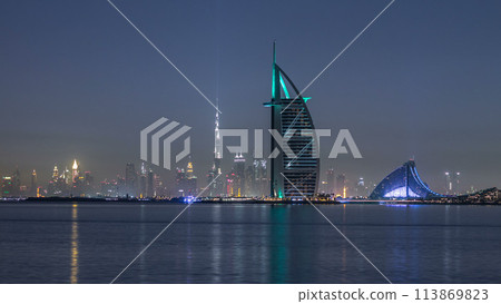 Skyline of Dubai by night with Burj Al Arab from the Palm Jumeirah timelapse. 113869823