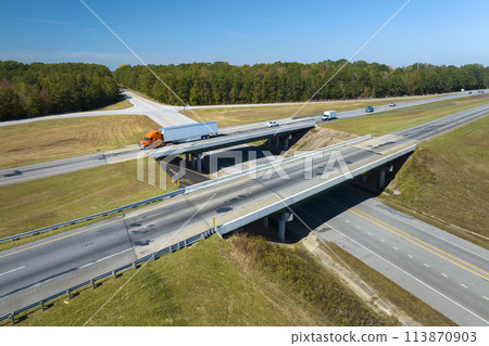 View from above of busy american highway with fast moving traffic between woods. Interstate transportation concept 113870903