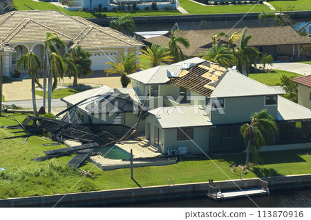 Hurricane Ian destroyed house roof in Florida residential area. Natural disaster and its consequences 113870916