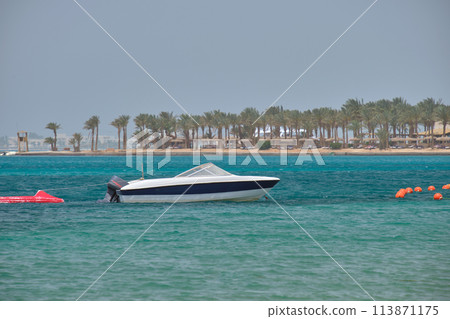 Seascape with ripple surface of blue sea water with white speedboat on anchor floating on calm waves 113871175