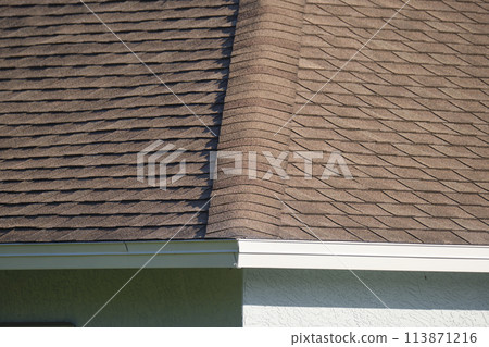 Closeup of house roof top covered with asphalt or bitumen shingles. Waterproofing of new building 113871216