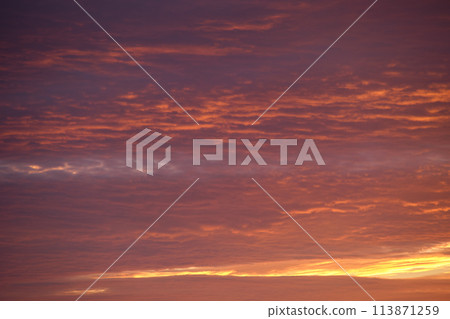 Bright colorful sunset sky with vivid smooth clouds illuminated with setting sun light spreading to horizon Bright colorful sunset sky with vivid smooth clouds illuminated with setting sun light spreading to horizon 113871259