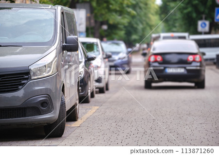 City traffic with cars parked in line on street side City traffic with cars parked in line on street side 113871260