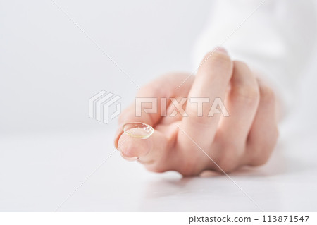 戴隱形眼鏡的女人的手指 戴隱形眼鏡的女人的手指 113871547