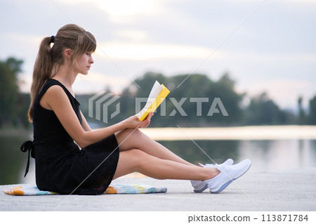 Young woman resting in summer park reading a book. Education and sudy concept. Young woman resting in summer park reading a book. Education and sudy concept. 113871784