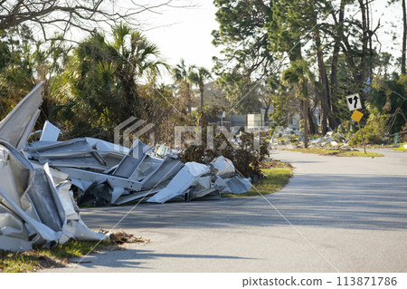 Piles of rubbish on street side from severely damaged houses after hurricane in Florida mobile home residential area. Consequences of natural disaster Piles of rubbish on street side from severely damaged houses after hurricane in Florida mobile home residential area. Consequences of natural disaster 113871786