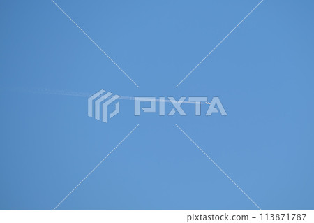 Distant passenger jet plane flying on high altitude on clear blue sky leaving white smoke trace of contrail behind. Air transportation concept 113871787