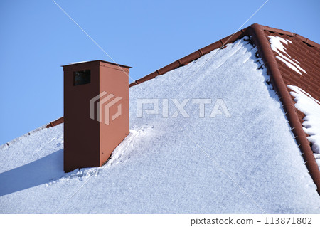 Closeup of house roof top covered with snow in cold winter. Tiled covering of building in wintertime weather 113871802