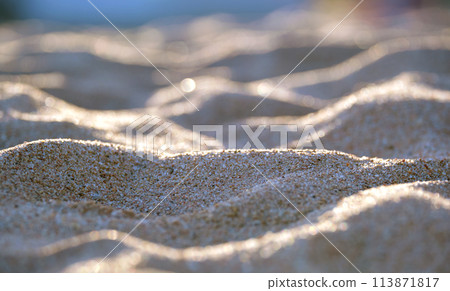 Close up of clean yellow sand surface covering seaside beach illuminated with evening light. Travel and vacations concept 113871817